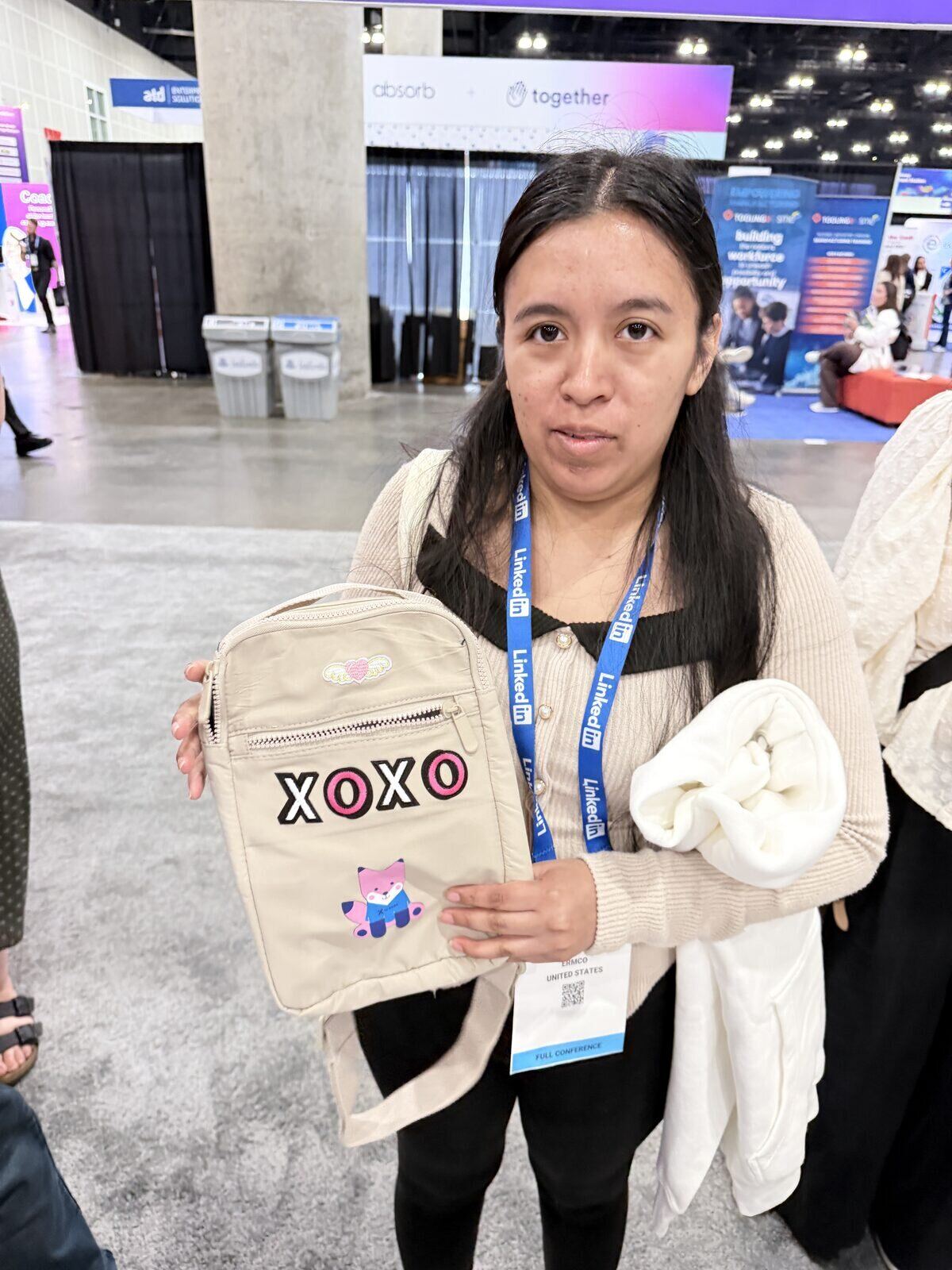 Conference attendee with a lanyard holding a crossbody bag customized with embroidered patches